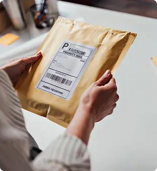 Person holding a protective certificate shipping envelope